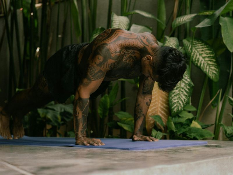 A focused man performing a core stability exercise on a mat.