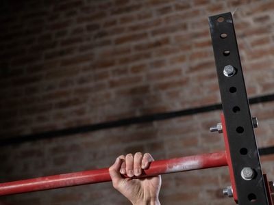 Close up of hands gripping a pull-up bar firmly.